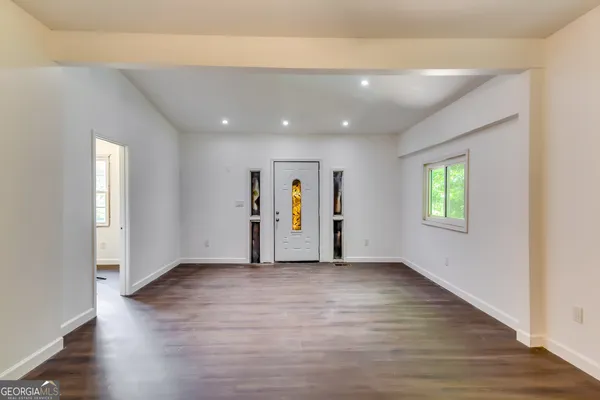 an empty room with window and wooden floor