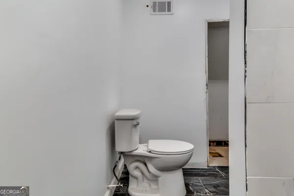 a white toilet sitting next to a white cabinet