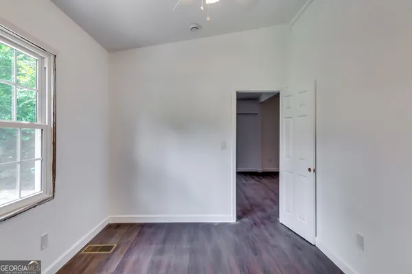 a view of a room with wooden floor and a window