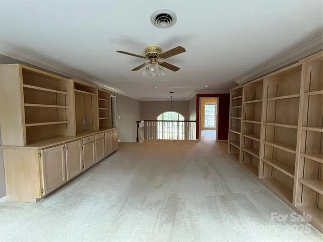 a view of empty room with windows and cabinet