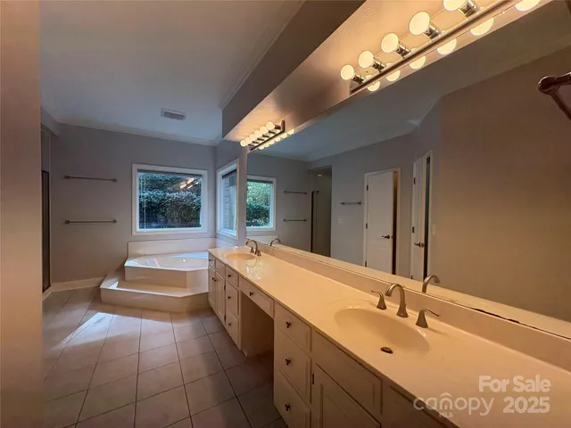 a spacious bathroom with a double vanity sink and a large mirror