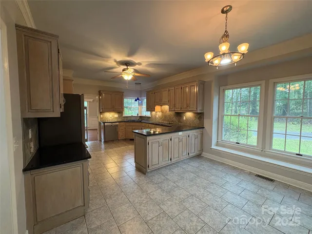 a kitchen with stainless steel appliances granite countertop a stove a sink a refrigerator and a cabinets