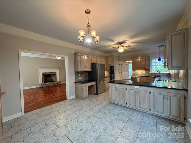 a large kitchen with kitchen island granite countertop a large counter space a sink appliances and cabinets