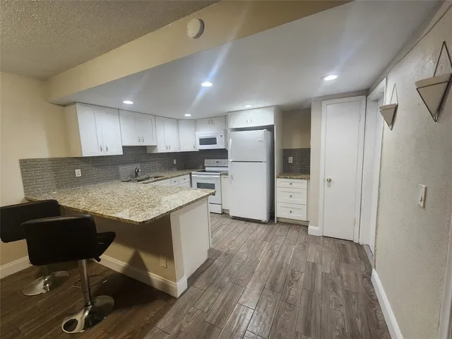 a kitchen with refrigerator and chairs