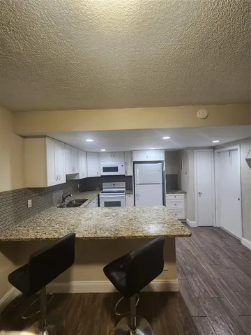 a kitchen with a sink cabinets and wooden floor