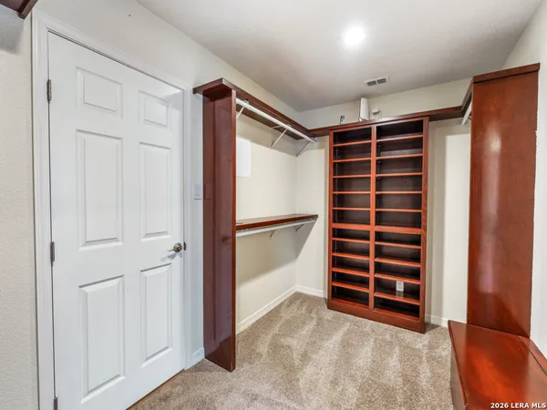 a view of walk in closet with empty racks