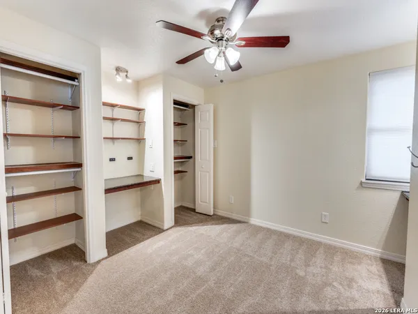 a view of an empty room with a cabinet and a window