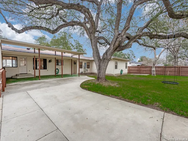 a front view of a house with a yard and trees