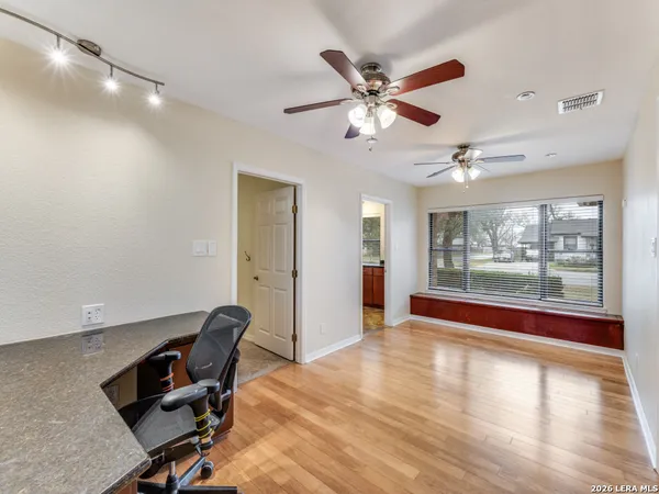a view of a workspace with furniture and a window