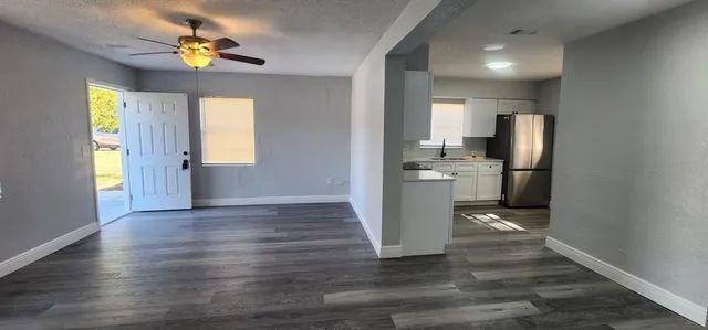 a view of kitchen with granite countertop cabinets and refrigerator