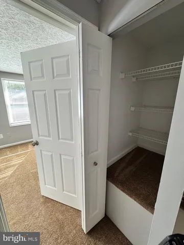 a view of an empty room with wooden floor and cabinet