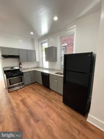 a kitchen with granite countertop a refrigerator and a sink