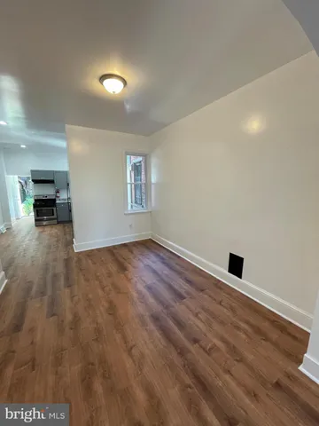 a view of empty room with wooden floor and fireplace