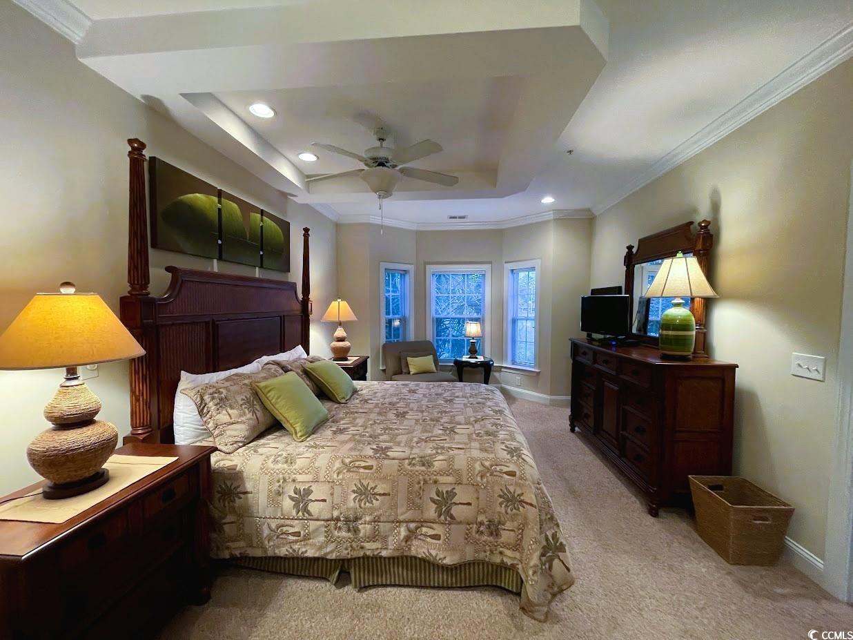 1008 Ray Costin Way, Unit 310 Murrells Inlet, SC 29576 - Photo 25 of 40 Bedroom with ceiling fan, a tray ceiling, light carpet, and ornamental molding