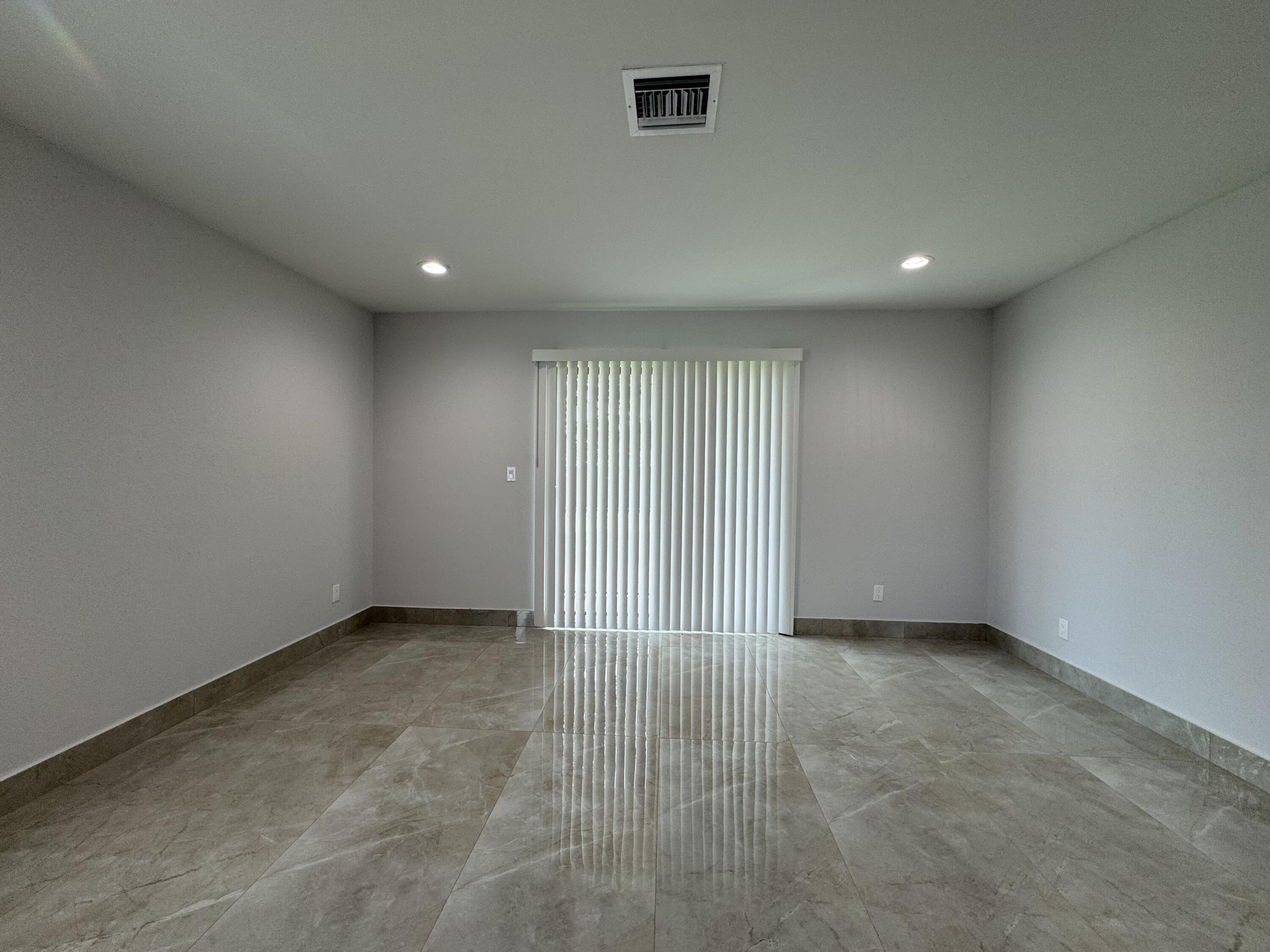 400 Northeast 30th Street, Unit 2 Pompano Beach, FL 33064 - Photo 19 of 22 an empty room with wooden floor and windows