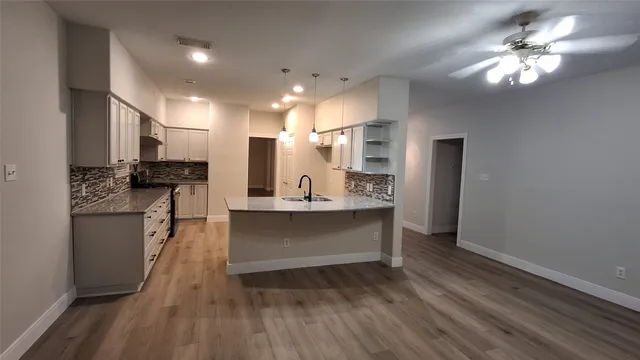 a open kitchen with kitchen island white cabinets and stainless steel appliances
