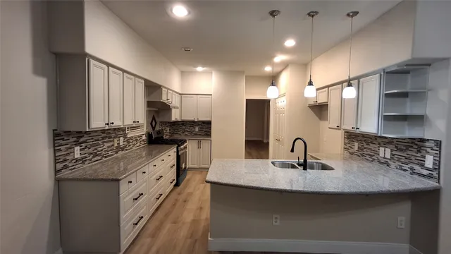 a kitchen with stainless steel appliances granite countertop a sink a stove and a refrigerator