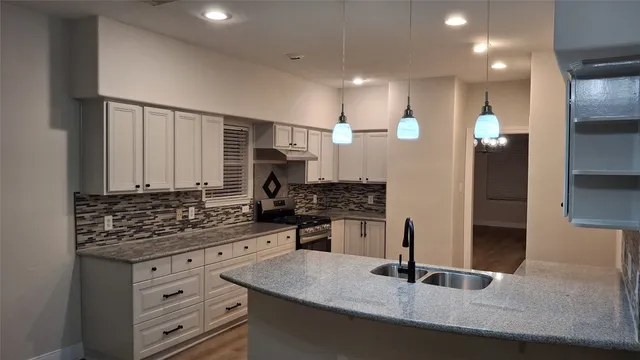 a kitchen with stainless steel appliances granite countertop a sink stove and cabinets