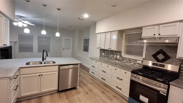a kitchen with sink stove and cabinets