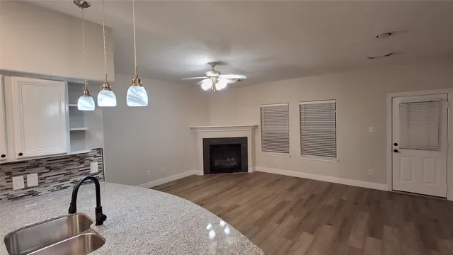 a view of a livingroom with a fireplace a chandelier and wooden floor