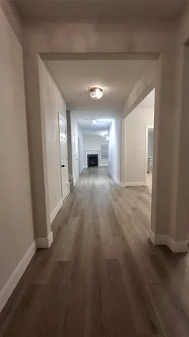 en empty room with wooden floor fireplace and windows