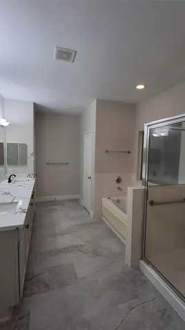 a bathroom with a tub sink and mirror