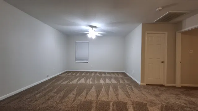 a view of empty room with ceiling fan