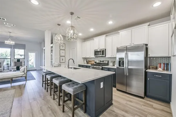 a large kitchen with kitchen island a refrigerator a stove a dining table and chairs