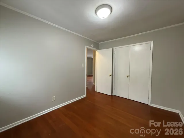 an empty room with wooden floor and window