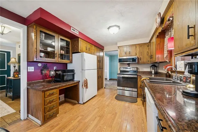 a kitchen with stainless steel appliances granite countertop a stove refrigerator sink and cabinets