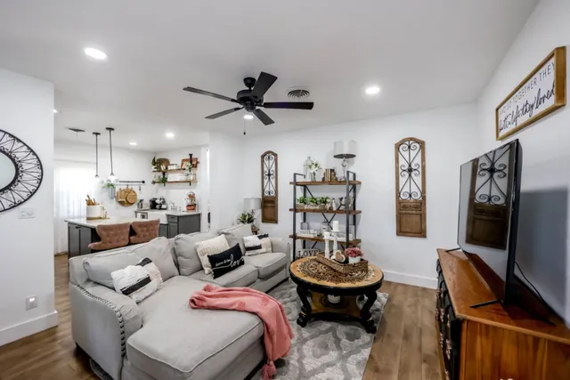 a living room with furniture a flat screen tv and kitchen view