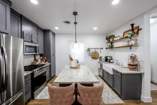 a kitchen with stainless steel appliances granite countertop a sink a stove and a refrigerator