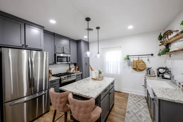 a kitchen with kitchen island a counter top space stainless steel appliances and cabinets