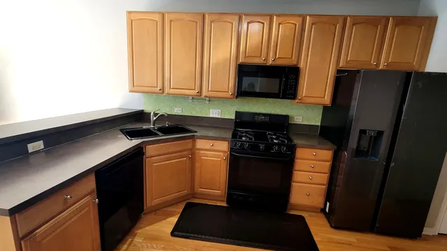 a kitchen with granite countertop a refrigerator stove and sink