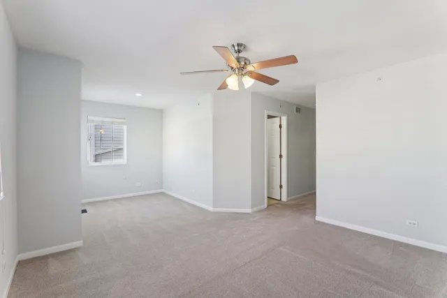 an empty room with closet and a ceiling fan