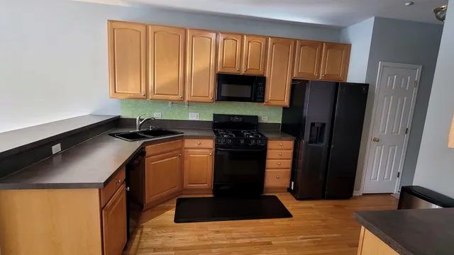 a kitchen with a sink a refrigerator and cabinets