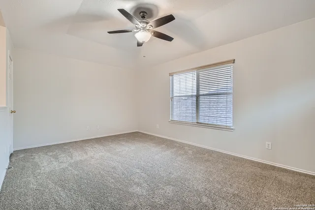 an empty room with a window and a fan