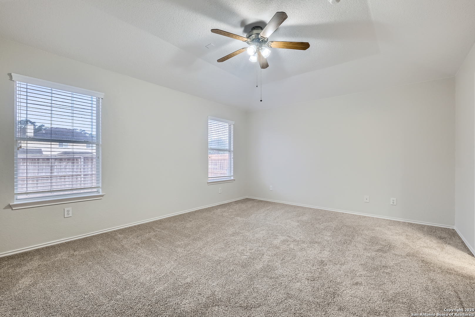 431 Woodstone Loop Cibolo, TX 78108 - Photo 19 of 29 an empty room with chandelier fan and windows