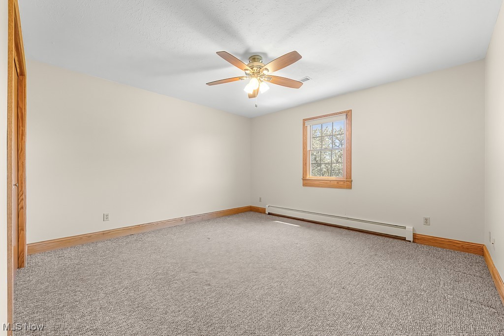8690 Friendsville Road Lodi, OH 44254 - Photo 30 of 50 Carpeted empty room featuring ceiling fan, baseboard heating, and baseboards