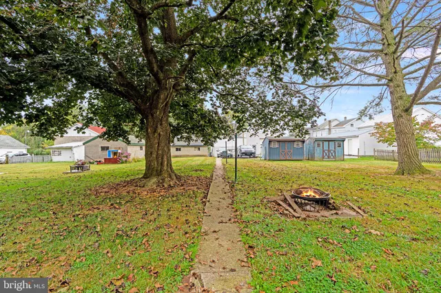 a large tree in front of a house with a yard