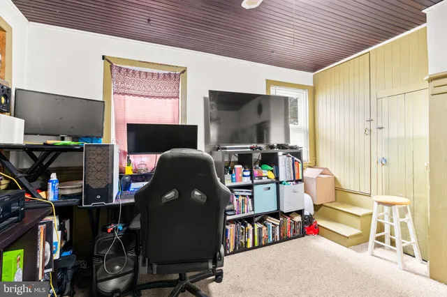 a work room with furniture a flat screen tv and a floor to ceiling window
