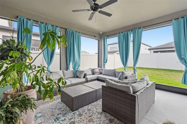 a living room with patio furniture and a potted plant