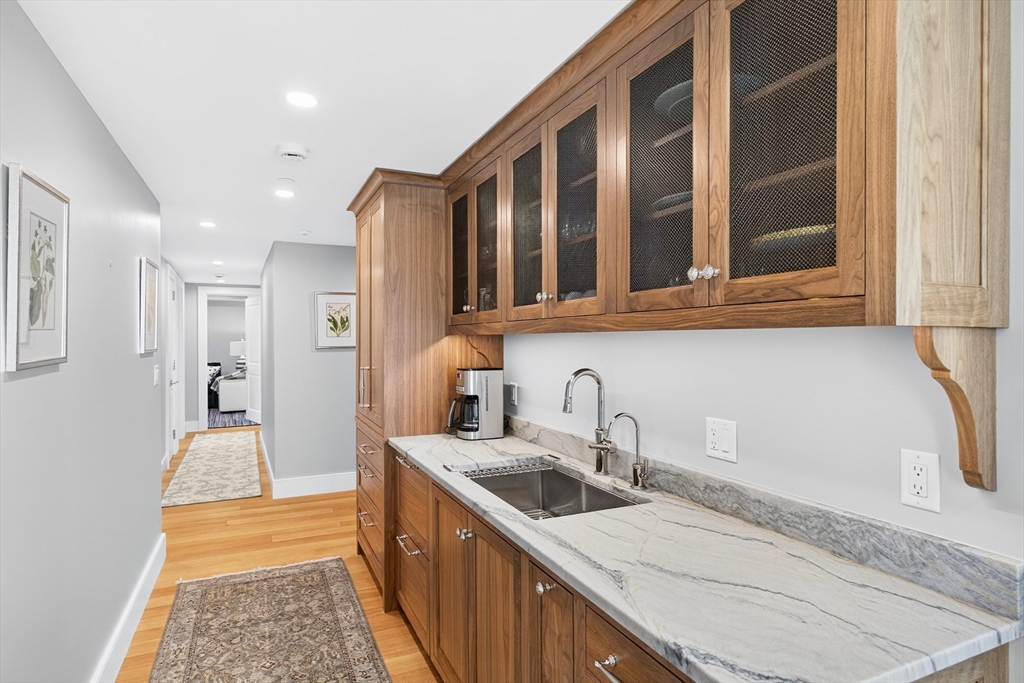 10 Rowes Wharf, Unit PH4 Boston, MA 02110 - Photo 20 of 42 a kitchen with stainless steel appliances granite countertop a sink and dishwasher stove a refrigerator with wooden cabinets