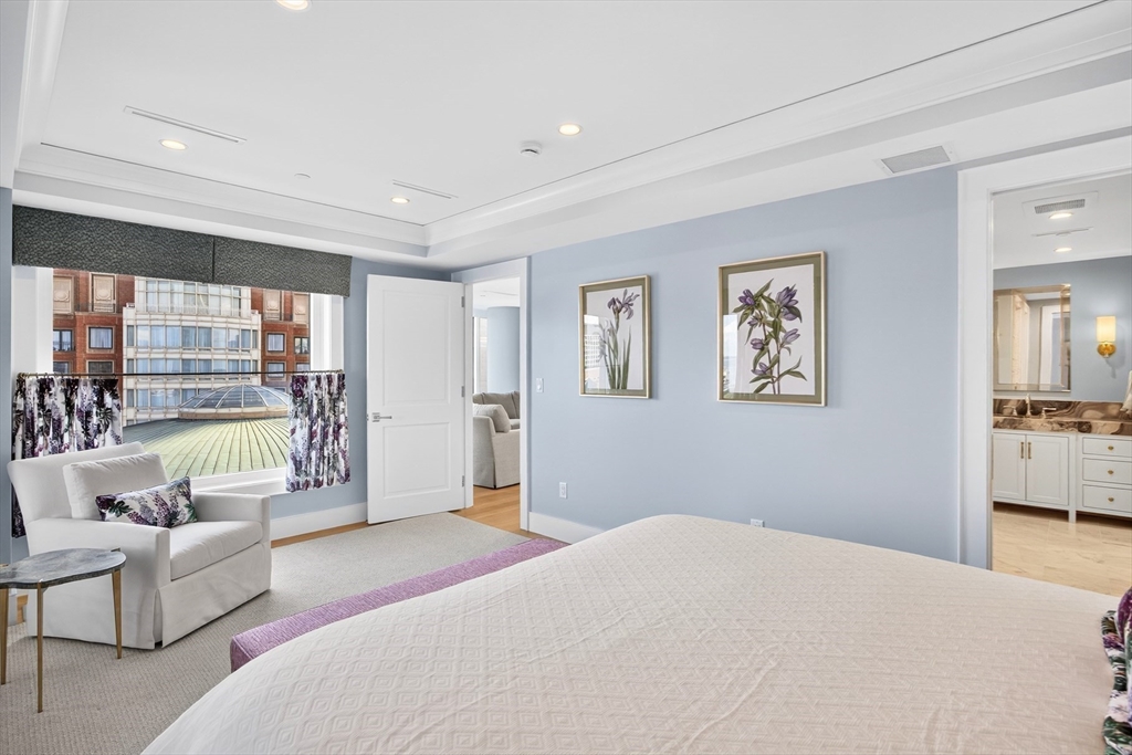 10 Rowes Wharf, Unit PH4 Boston, MA 02110 - Photo 25 of 42 a bedroom with a large bed couch and a large window