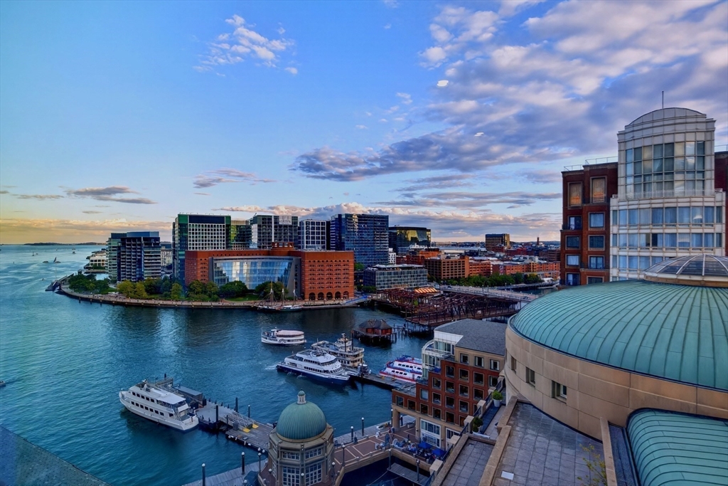 10 Rowes Wharf, Unit PH4 Boston, MA 02110 - Photo 39 of 42 a view of a balcony with dining table and chairs with wooden floor