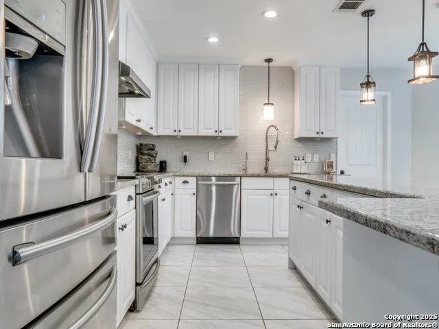 a kitchen with white cabinets stainless steel appliances and sink