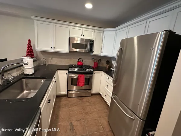 a kitchen with granite countertop a sink cabinets and appliances