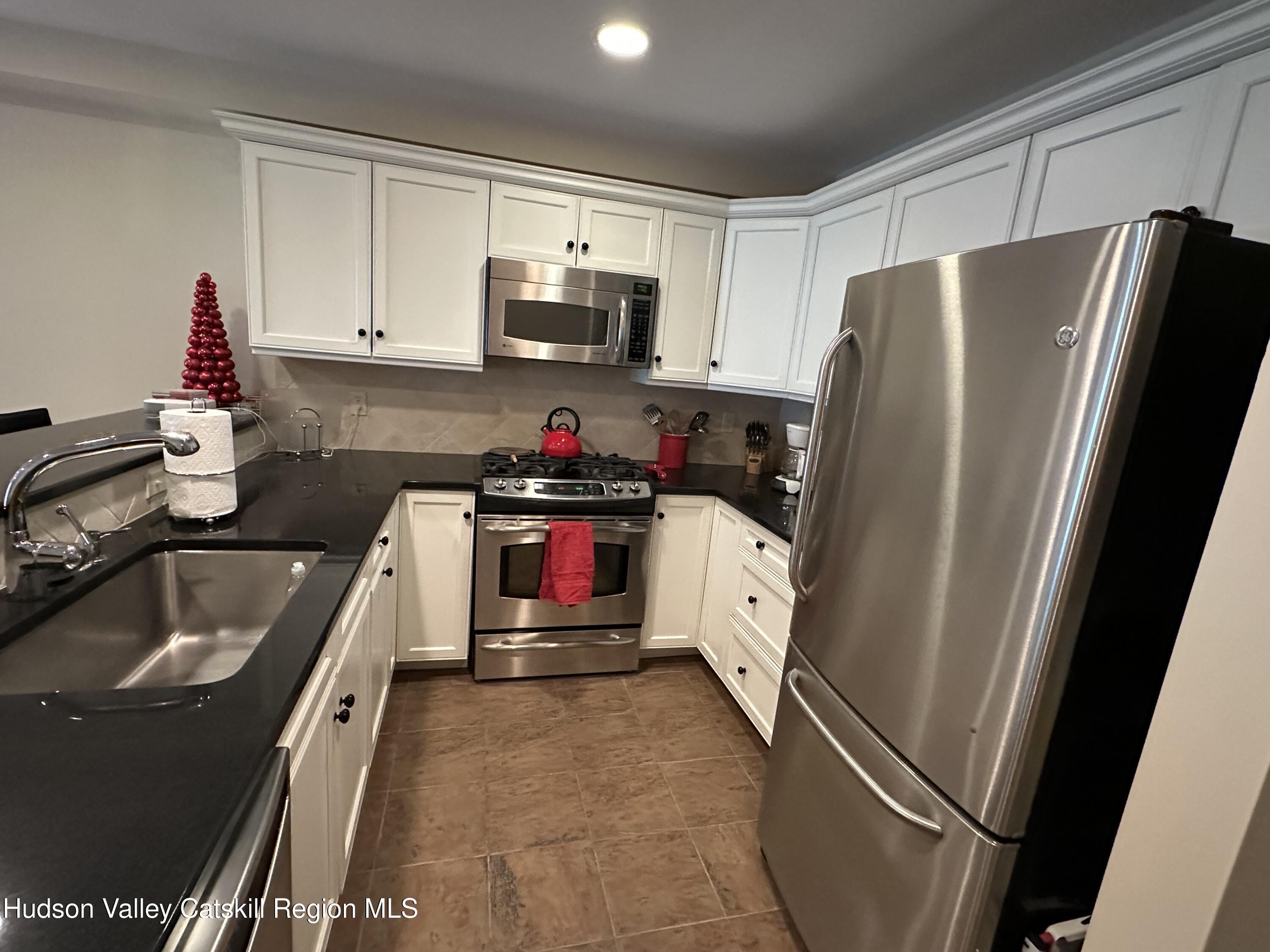 274 Brooksburgh Road, Unit 67 Hensonville, NY 12439 - Photo 17 of 36 a kitchen with refrigerator a sink and cabinets