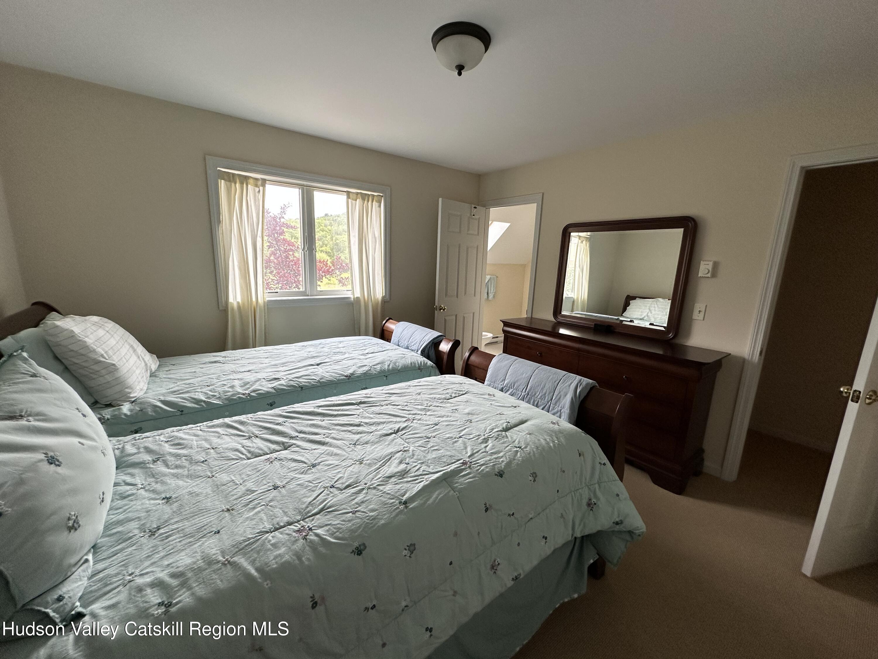 274 Brooksburgh Road, Unit 67 Hensonville, NY 12439 - Photo 24 of 36 a bedroom with a bed and a mirror on dresser