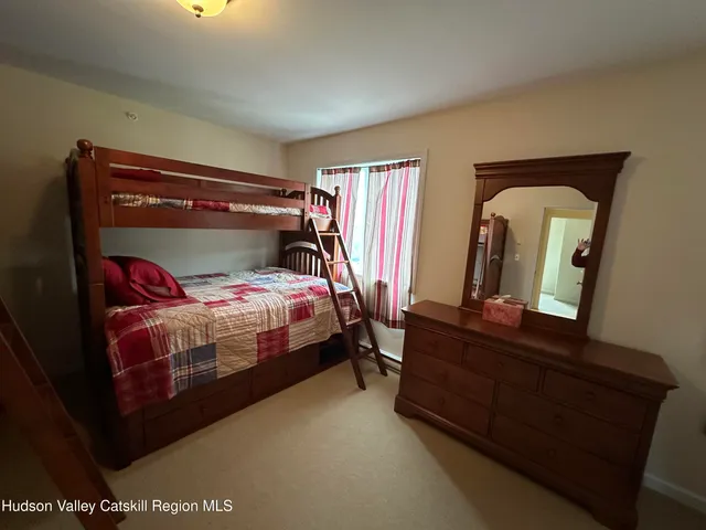 a bedroom with two bunk beds and a dresser